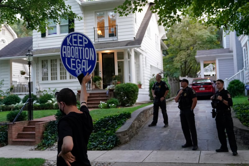 A protester stands outside the home of Supreme Court Justice Brett Kavanaugh, Monday, Sept. 13, 2021, in Chevy Chase, Md.