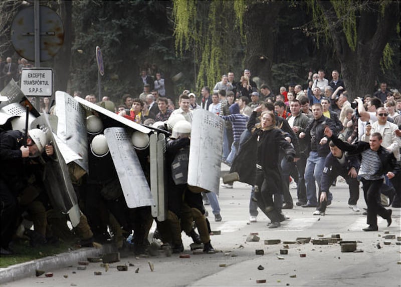 Anti-communist demonstrators throw bricks at a phalanx riot police outside the presidential palace Tuesday in Chisinau, Moldova, during protests against the declared results of Sunday's parliamentary elections. Many thousands of demonstrators attempted t