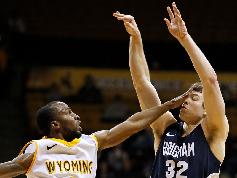 Wyoming guard JayDee Luster, left, hits BYU guard Jimmer Fredette (32) in the face as Fredette follows through on a 3-point basket during a game in 2011.