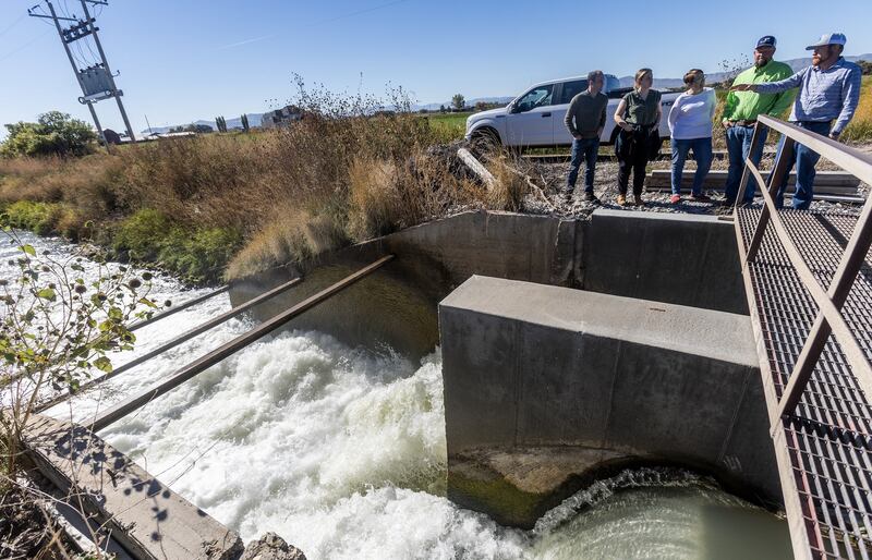 Trevor Nielson of the Bear River Canal Co., right, talks about the new, high-tech gates and other issues with water officials during a tour of various canal sites in Box Elder County on Oct. 19.