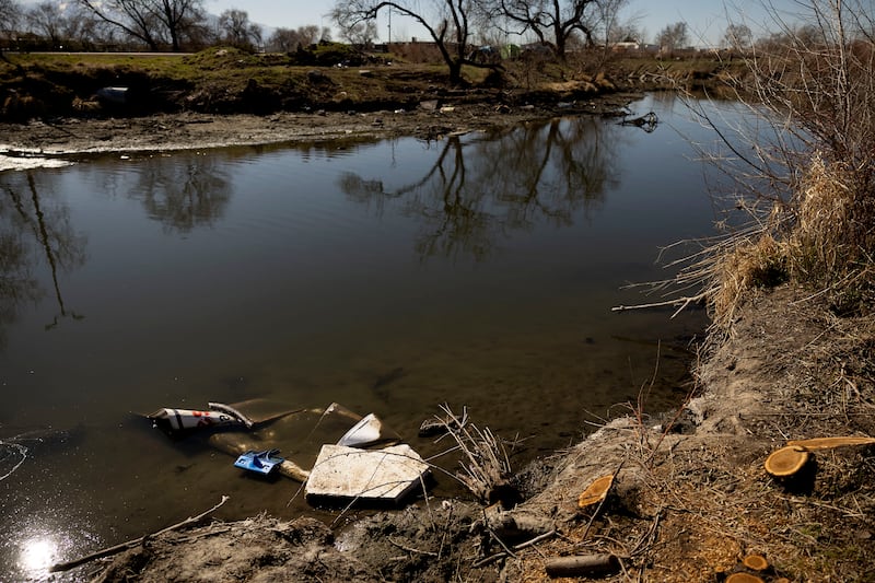 Garbage floats in the Jordan River in Salt Lake City on Wednesday, March 23, 2022.