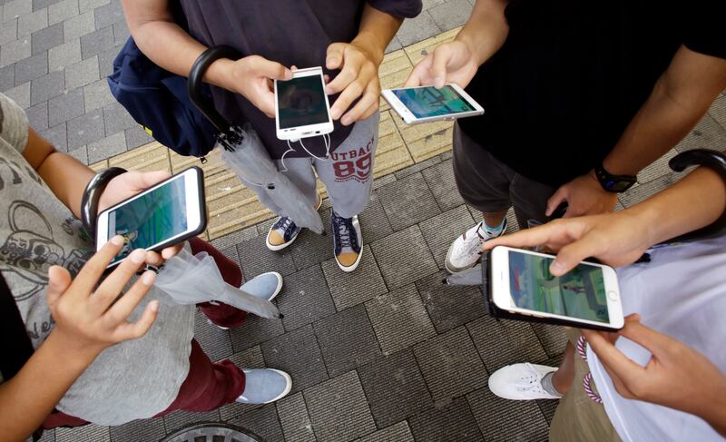 People maneuver their smartphones as they play “Pokemon Go” at Akihabara in Tokyo, Friday, July 22, 2016. The Icelandic yogurt company, siggi, announced their Digital Detox Program challenge.