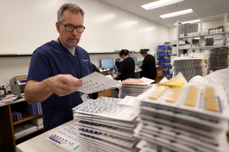 Pharmacist Mike Aasheim sorts medication blister packs at the new Utah State Correctional Facility in Salt Lake City on Thursday, June 30.
