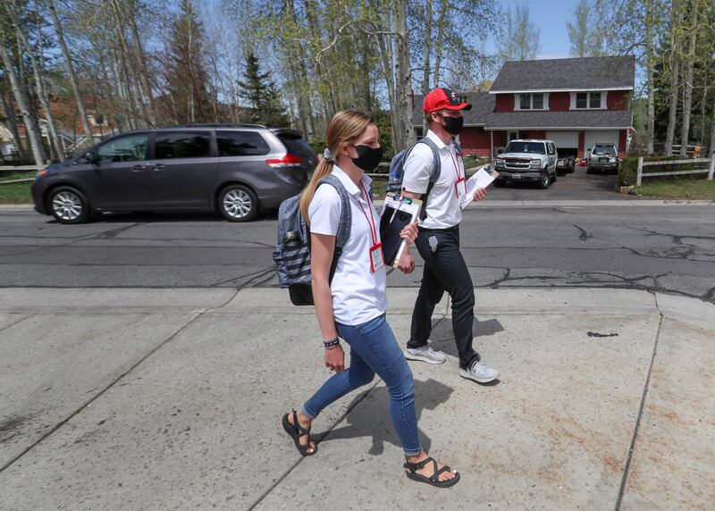 McKenna Hunt and Max Schultz, students with the University of Utah’s David Eccles School of Business, deliver flyers or door hangers explaining the Utah Health & Economic Recovery Outreach program in Park City on Wednesday, May 6, 2020.