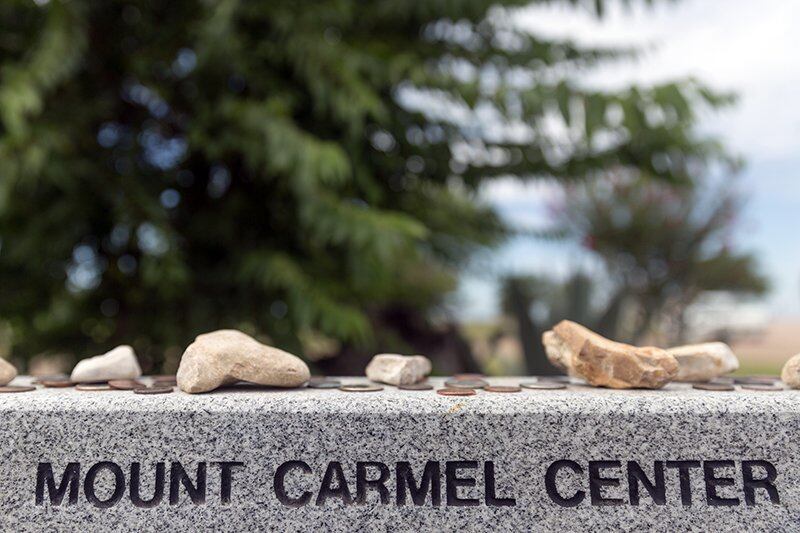 Stones and coins on top of a monument to the Branch Davidians killed in the 1993 Waco siege at Mount Carmel Center, the Branch Davidian compound, outside of Waco, Texas.
