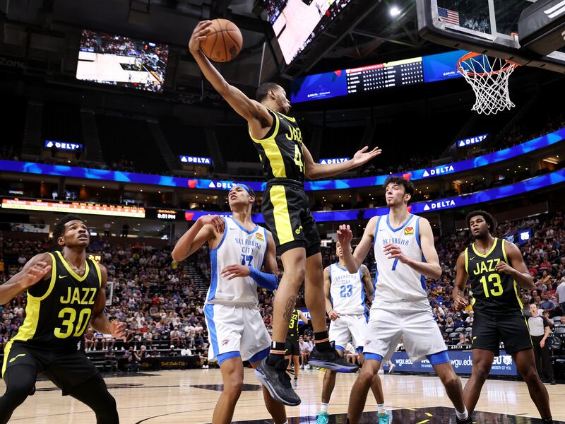 Utah’s Taevion Kinsey grabs a rebound over Oklahoma City’s Tre Mann and Chet Holmgren as the Jazz and Thunder play in Summer League action.