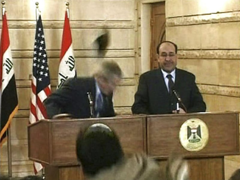 In a video image, a man throws a shoe at President George W. Bush during a news conference with Iraq Prime Minister Nouri al-Maliki. "This is your farewell kiss, you dog!" the protester shouted.