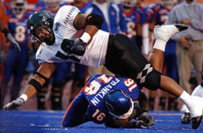 Hawaii running back West Keliikipi gets tackled by Boise State cornerback Gabrial Franklin during the Broncos' 69-3 win Friday.