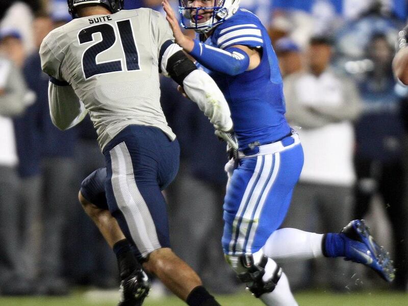 BYU's Taysom Hill prepares to be tackled by Utah State safety Brian Suite during the Aggies' victory over the Cougars.