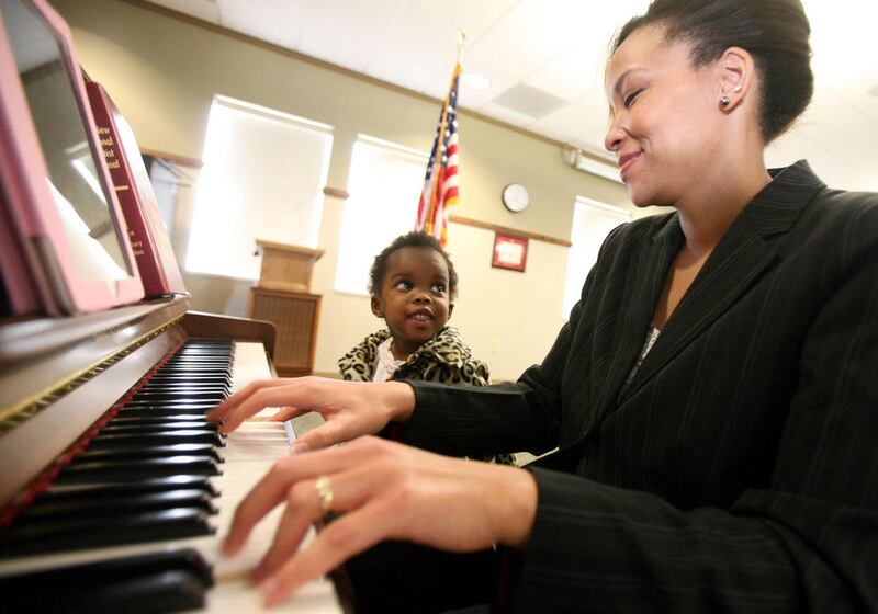 Mikaya Oliver watches her mother Detorea Oliver play piano during a ceremony honoring Pearl Harbor survivors at the George Whalen Veterans Home in Ogden on Friday, Dec. 7, 2012.