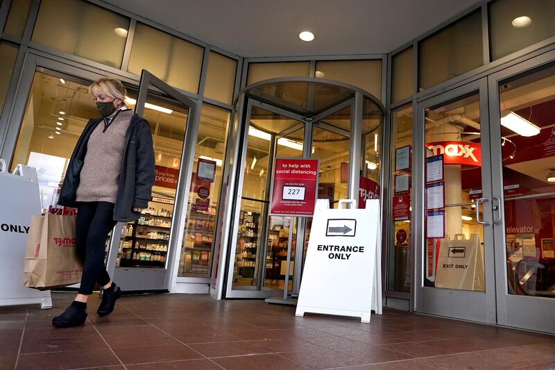 In this Oct. 27, 2020, file photo, a shopper steps out of a department store in Boston. Defying fears of another slowdown, U.S. businesses kept hiring at a solid pace in October yet there are signs they remain cautious about the economy’s future as the pandemic worsens.