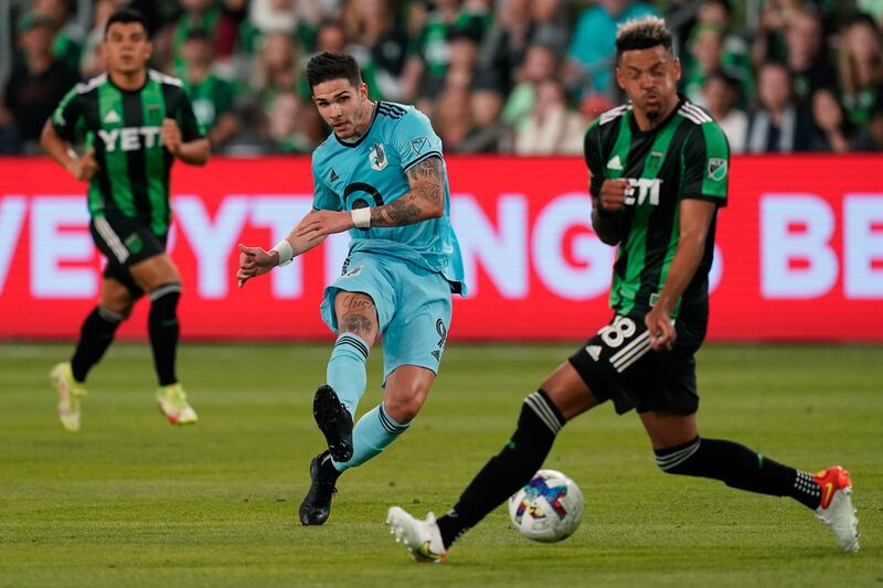 Minnesota United FC forward Luis Amarilla, wearing blue, moves the ball past Austin FC defender Julio Cascante
