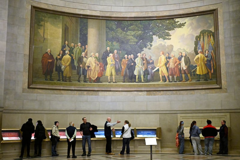 A large wall mural showing the signing of the Declaration of Independence is seen over visitors at the National Archives, Jan. 29, 2026, in Washington, D.C.