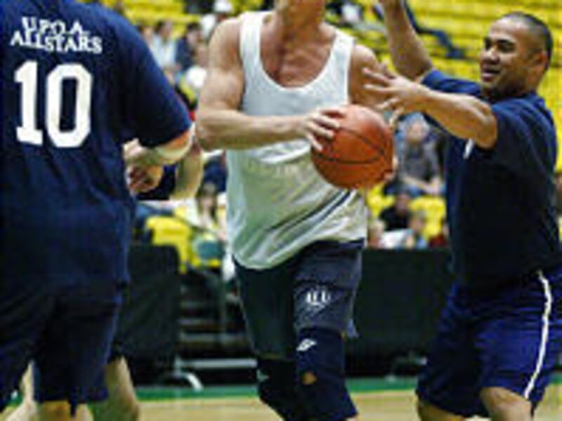 Former Denver Bronco tight end Ron Egloff drives the lane as Silver Brown, right, takes a swipe at the ball during a fund-raiser at UVSC.