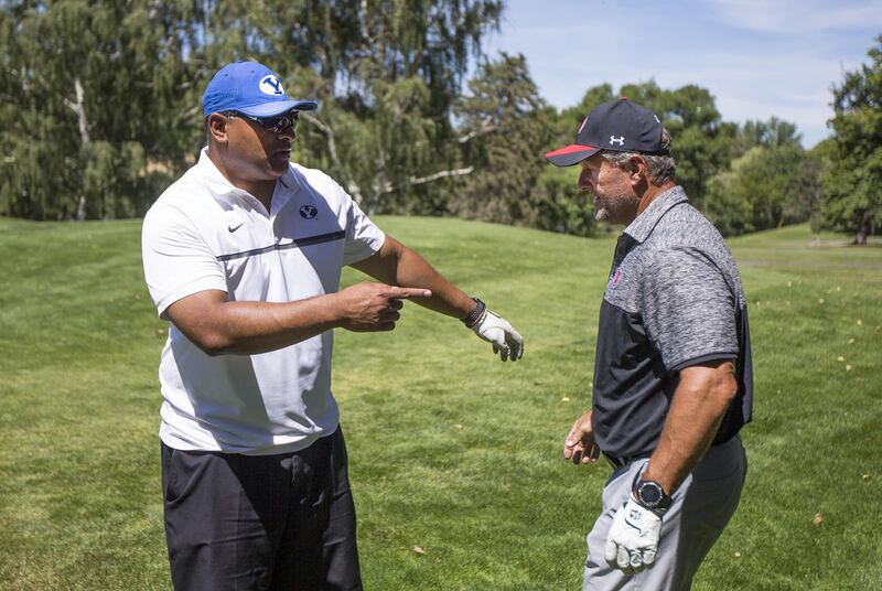 FILE: BYU coach Kalani Sitake, left, and University of Utah's coach Kyle Whittingham prepare to pose for a photo during the annual National Kidney Foundation fundraiser and golf invitational at Hidden Valley Country Club in Sandy on June, 19, 2017.
