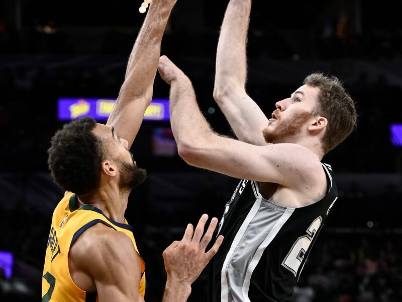 San Antonio Spurs’ Jakob Poeltl, wearing black, shoots against Utah Jazz’s Rudy Gobert, wearing yellow