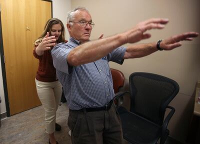 Physician assistant Meghan Zorn tests Art Eichbauer's ability to catch himself when pulled backward during an appointment to adjust his deep brain stimulator for Parkinson's treatment at the Imaging & Neurosciences Center at the University of Utah on Wedn