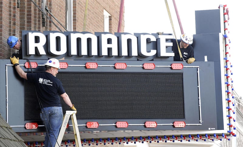 Workers from Young Electric Sign Company install the new marquee on the Romance Theater in Rexburg, Idaho.
