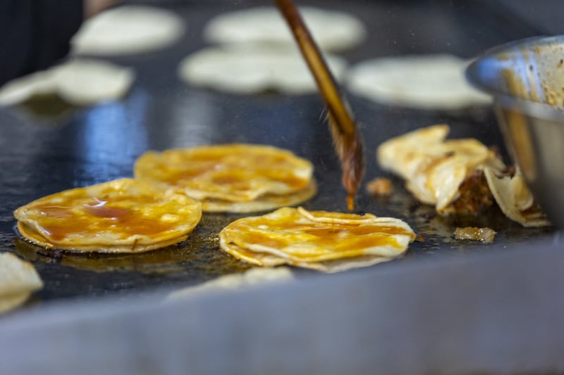 Claudia Martinez brushes tortillas at TacoMania in Riverton on Saturday, Nov. 12, 2022.