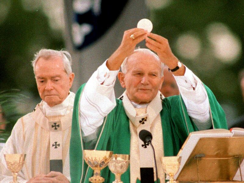 In a 1987 photo, Pope John Paul II raises the host in the sacred rite of Consecration during a Mass at the University of New Orleans during his visit in New Orleans. In the background is Archbishop Philip Hannan. Former Archbishop Philip Matthew Hannan, w