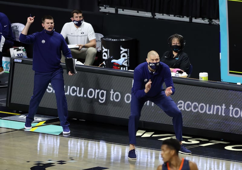 Brigham Young Cougars head coach Mark Pope claps and cheers for his team on the sideline of the Orleans Arena in Las Vegas.