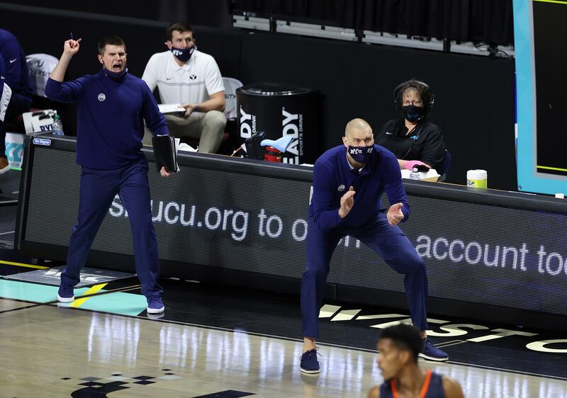 Brigham Young Cougars head coach Mark Pope claps and cheers for his team on the sideline of the Orleans Arena in Las Vegas.