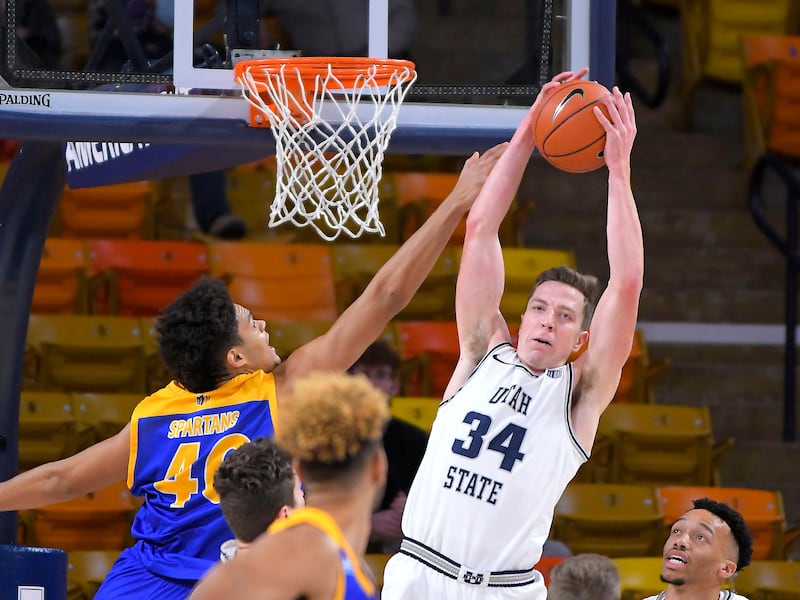 Utah State forward Justin Bean jumps to grab a rebound next to San Jose State forward Chase Courtney