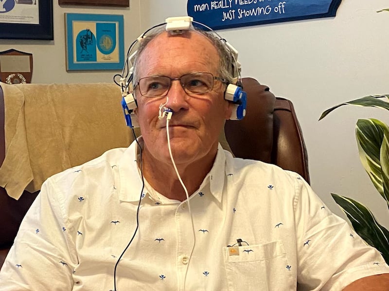 Former college and pro linebacker Larry Carr wears a Vielight headset during an infrared light therapy session.