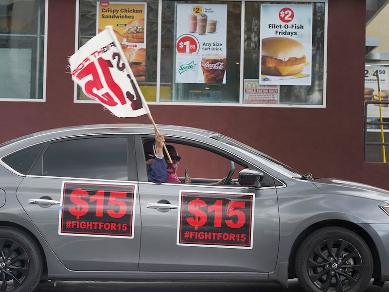 Fast-food workers drive though a McDonald’s restaurant demanding a $15 hourly minimum wage in East Los Angeles.