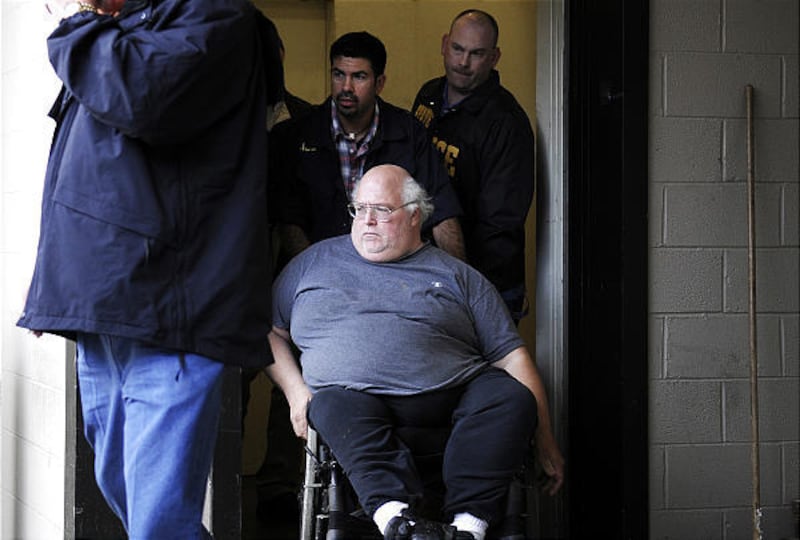 A man, center in wheelchair, arrested in connection with a series of explosive devices found in east Texas mailboxes during the past month, is escorted by federal officials to a transport van in Tyler, Texas on April 7, 2010 to be taken to the Smith Count
