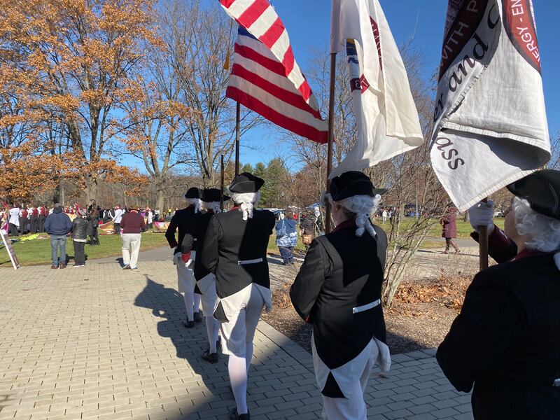 A group of Minutemen carry flags outside of McGuirk Alumni Stadium in Amherst, Mass., ahead of the BYU vs. UMass game.