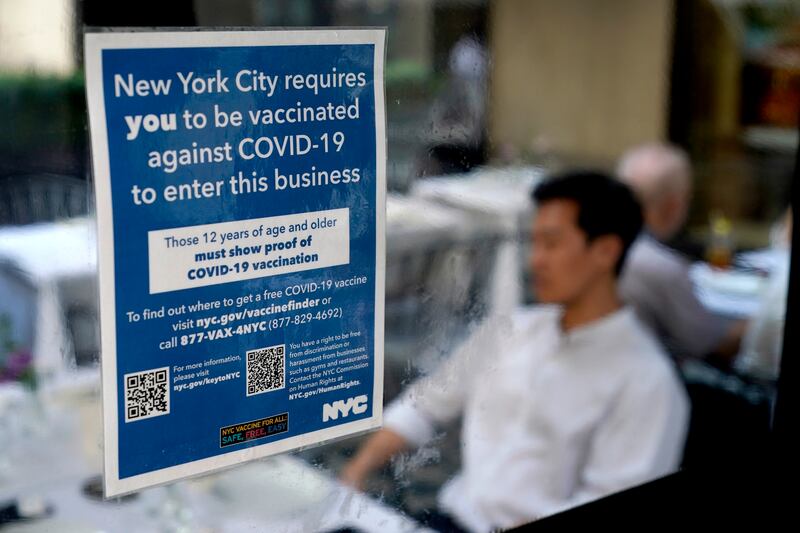 A notice explains that proof of vaccination is required to dine inside is seen at a restaurant in midtown Manhattan in New York.