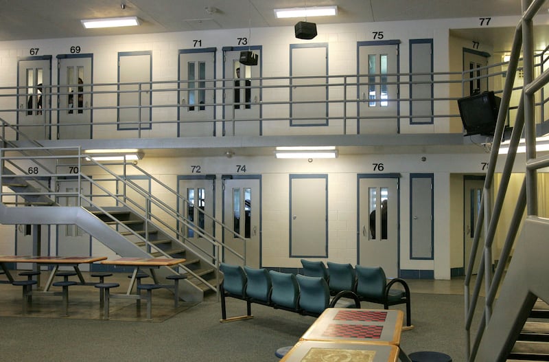 Some inmates at the Utah County Jail peer out from the jail cells.