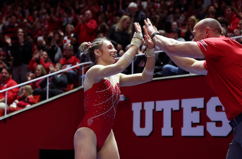 Utah’s Grace McCallum is congratulated by vault coach Jimmy Pratt as No. 4 Utah takes on No. 5 UCLA in Salt Lake City on Feb. 3, 2023.