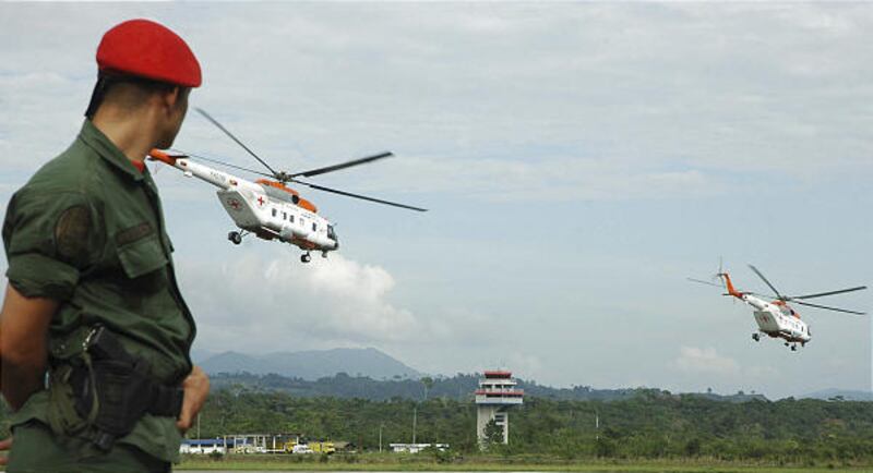 A soldier watches two helicopters leave Santo Domingo, Venezuela, Friday for Colombia.