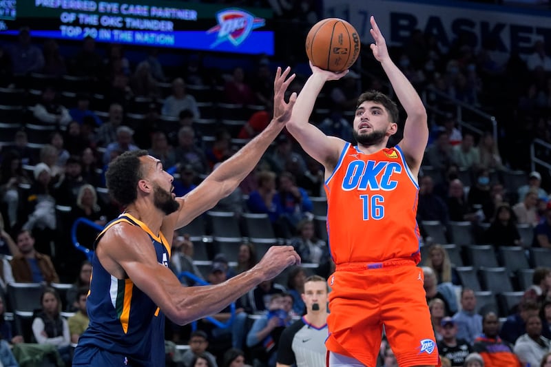 Oklahoma City Thunder guard Ty Jerome, wearing orange, shoots over Utah Jazz center Rudy Gobert, wearing blue