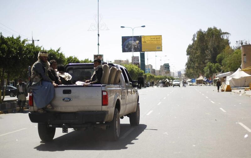 Houthi Shiite rebels riding on a pickup truck, patrol a street while other members dismantle a protest camp on a road leading to the Sanaa Airport in Sanaa, Yemen, Friday, Oct. 17, 2014.