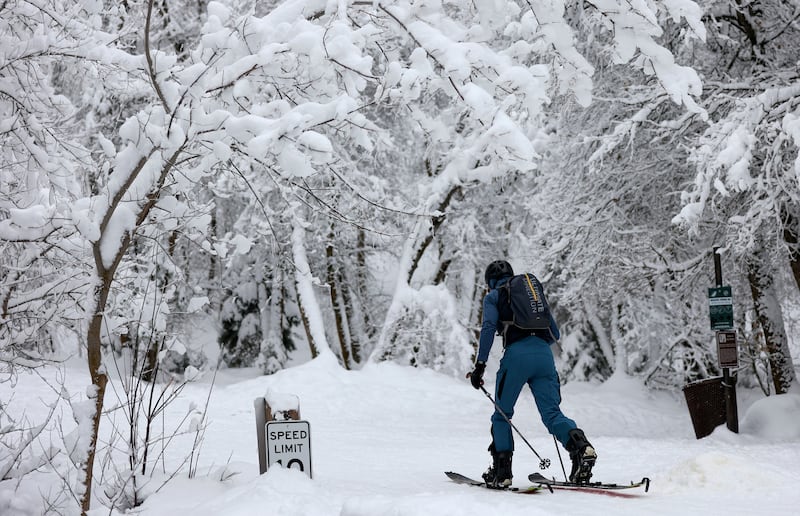 James Donigan split-boards past a partially buried speed limit sign in Millcreek Canyon.