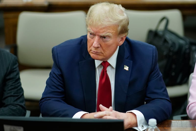 Former President Donald Trump, center, sits at the defense table with his attorneys at New York Supreme Court on Dec. 7, 2023.