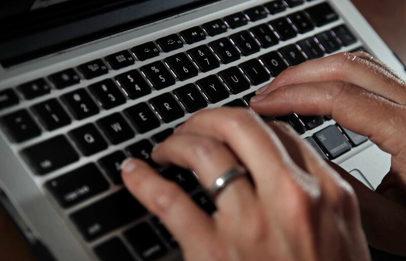 A person types on a laptop keyboard in North Andover, Mass.