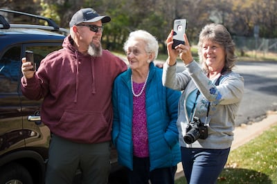 Delwin Stucki, left, Nila Stucki, and Dixie Stucki take a photo of the flag put up by a local group called Follow the Flag in honor of the late North Ogden Mayor Brent Taylor at Cold Water Canyon in North Ogden on Sunday, Nov. 11, 2018.