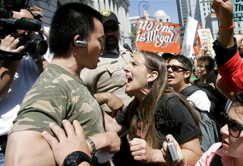 Isaac Chang of the Minutemen Project, left, argues with immigration supporter Lisa Roellig, of A.N.S.W.E.R., at a Minutemen rally to demand the resignation of Mayor Gavin Newsom over the San Francisco sanctuary law in San Francisco.