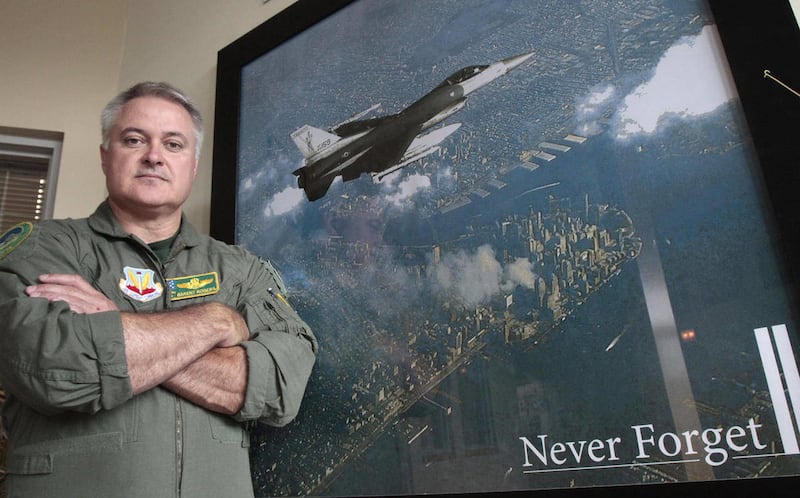 Lt. Col. Barent Rogers of the Vermont Air National Guard stands next to the photograph of him flying patrol over Ground Zero on Friday, Sept. 9, 2011 in South Burlington, Vt. The pilot photographed flying over Manhattan on Sept. 12, 2001 reflected on the