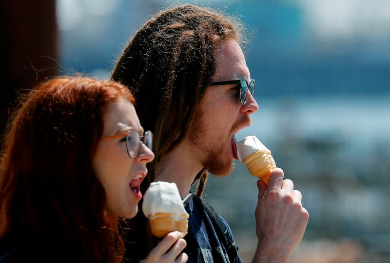 A couple eat ice creams in Brighton, England, Wednesday, May 20, 2020.