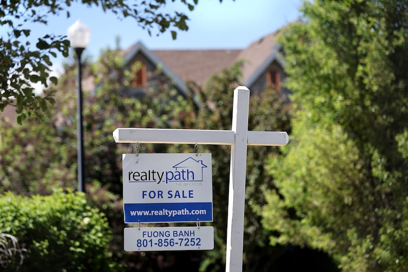 A “For Sale” sign is posted in the yard of a house in Sandy on Tuesday, May 31, 2022.