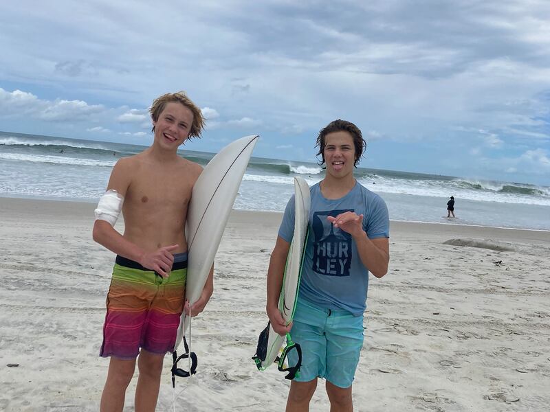 Doyle Nielsen, left, and his brother Logan were surfing on Sept. 9 at New Smyrna Beach in Florida when a shark bit Doyle’s arm.