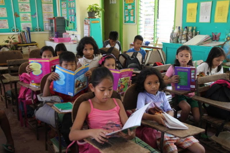 Filipino school children read in a library built by the Rise & Rebuild Foundation.