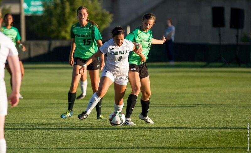 Utah Valley sophomore midfielder Laken Flinders (center) dribbles the ball past a defender on Saturday night at Clyde Field in Orem.