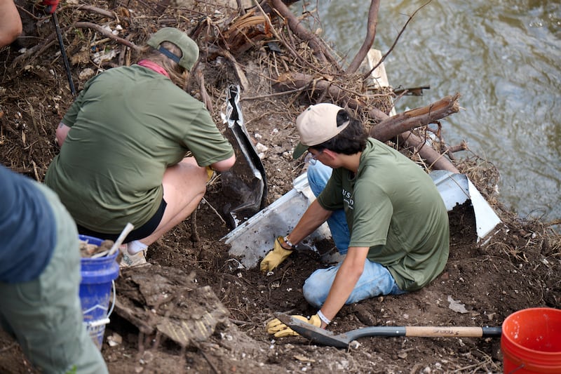 Volunteers gather items from the Guadalupe River in Hunt, Texas, on July 26, 2025, following the severe flooding in central Texas on July 4, 2025.