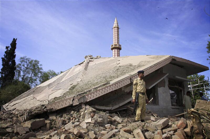 A Pakistani soldier stands on rubble of a collapsed mosque after a suicide car bombing in Nowshera near Peshawar, Pakistan, on Friday.